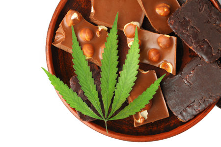 Healthy tasty chocolate chip marijuana cookie with green hemp leaf, CBD chocolate isolated white backgroundの写真素材