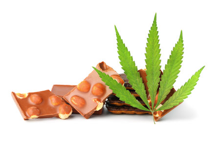 Pieces of delicious marijuana nut chocolate chip cookie with green hemp leaf, chocolate containing CBD, isolated white background. Premium high qualityの写真素材
