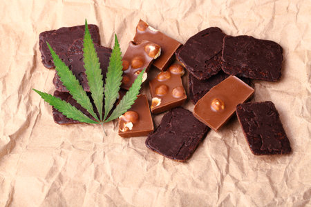 Organic Marijuana Pieces of Chocolate with CBD cannabis nuts and dry green hemp leaves. Chocolate coated hemp biscuits. Marijuana sweet food conceptの写真素材
