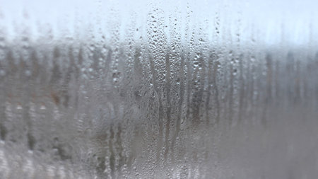 Background of natural condensation of water on transparent glass with high air humidity, large drops drippingの写真素材