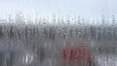Background of natural condensation of water on transparent glass with high air humidity, large drops drippingの写真素材