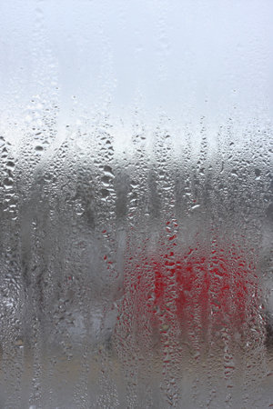 Background of condensation of water droplets on glass, humidity and fog behind glass, bad weather, rainの写真素材