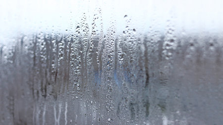 Background of condensation of water droplets on glass, humidity and fog behind glass, bad weather, rainの写真素材