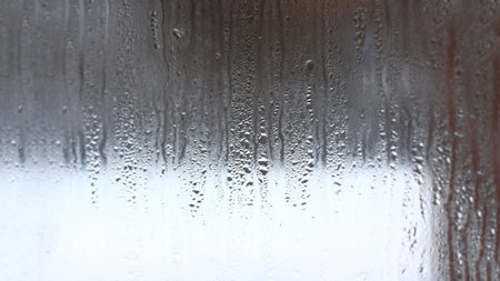 Background of natural condensation of water on transparent glass with high air humidity, large drops drippingの写真素材