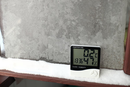 An electronic thermometer and hygrometer for temperature and humidity control is installed on the snow. The humidity indicator is indicated on the hygrometer of the deviceの写真素材