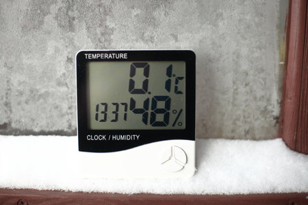 An electronic thermometer and hygrometer for temperature and humidity control is installed on the snow. The humidity indicator is indicated on the hygrometer of the deviceの写真素材
