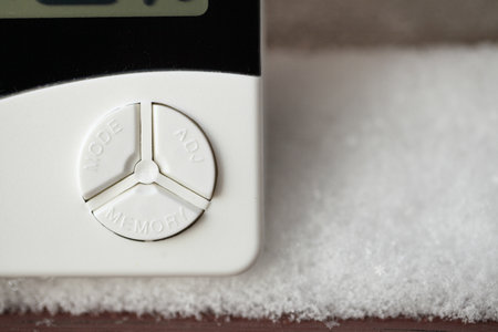 Control buttons of a large device for measuring temperature and humidity, a thermometer and a hygrometer with snowの写真素材
