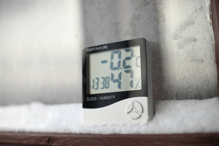 Measurement of the temperature and humidity, thermometer and hygrometer on a window with snow on the background of frozen glassの写真素材