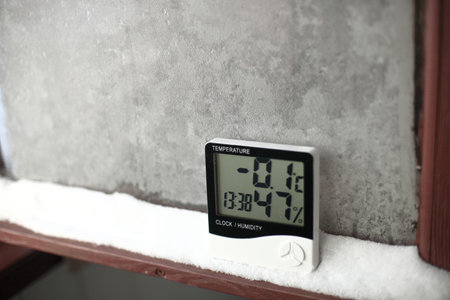 An electronic thermometer and hygrometer for temperature and humidity control is installed on the snow. The humidity indicator is indicated on the hygrometer of the deviceの写真素材