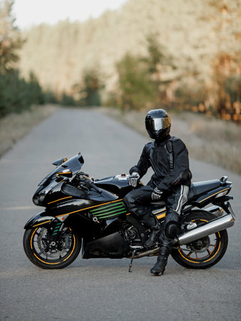Biker in a helmet and leather protective equipment sits on a motorcycle, a sporty fast motorcycleの写真素材
