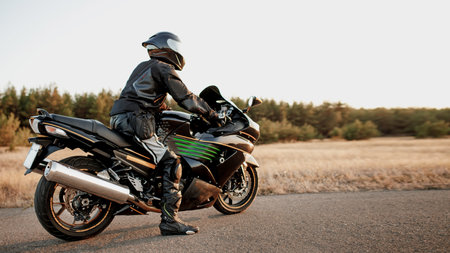 Sports bike rider wearing a helmet and leather protective gear on a fast sports bikeの写真素材