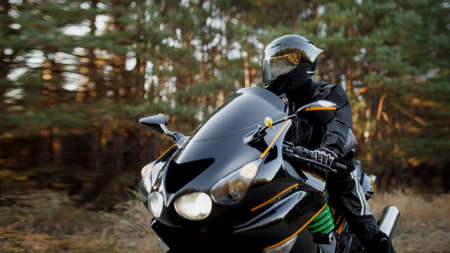 Sports bike rider wearing a helmet and leather protective gear on a fast sports bikeの写真素材