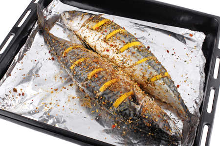 Two raw sea fish on a platter with seasoning foil and lemon slices on white isolated background. Healthy eating concept. Top viewの写真素材