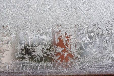Beautiful winter background, frost on the window, natural texture on glass with a frozen pattern....