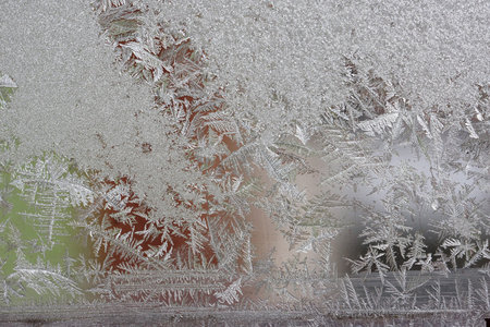 Beautiful winter background, frost on the window, natural texture on glass with a frozen pattern....