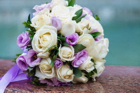 Beautiful wedding bouquet of natural flowers on a blurred background lies on graniteの写真素材