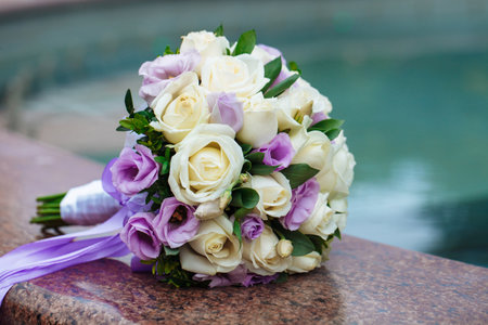 Beautiful wedding bouquet of natural flowers on a blurred background lies on graniteの写真素材