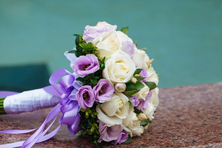 Beautiful wedding bouquet of natural flowers on a blurred background lies on graniteの写真素材
