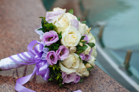 Beautiful wedding bouquet of natural flowers on a blurred background lies on graniteの写真素材