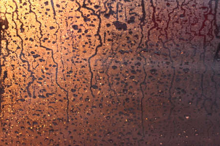 Natural background of condensation of water on a window glass with high air humidity, large drops dripping. Natural sunlight through glass. High humidityの写真素材
