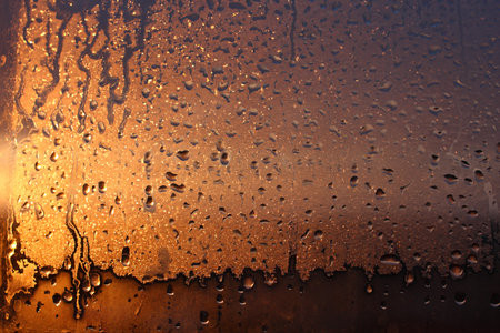 Window transparent glass with condensation, high humidity in the room, large drops of water flow...