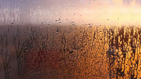 Natural background of condensation, drops of flowing water on the window paneの写真素材
