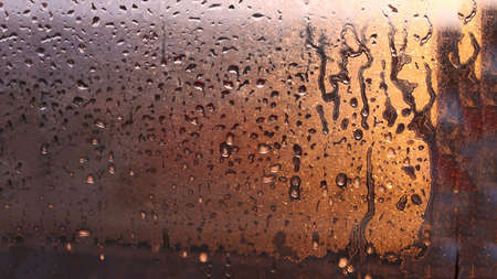 Drops of condensate on the sweaty glass window. Cold foggy glass. Wet window background, texture condensation with dripping dropsの写真素材