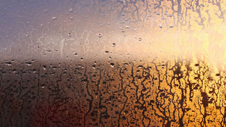Drops of condensate on the sweaty glass window. Cold foggy glass. Wet window background, texture condensation with dripping dropsの写真素材