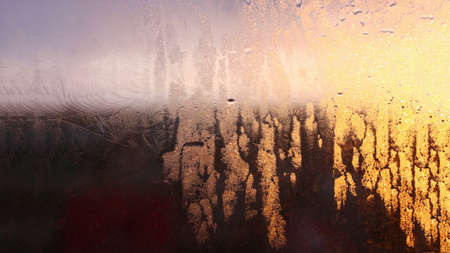 Drops of condensate on the sweaty glass window. Cold foggy glass. Wet window background, texture condensation with dripping dropsの写真素材