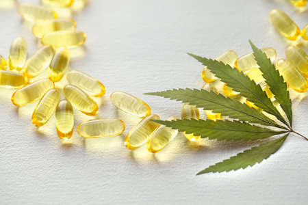 Medical cannabis products, leaf, capsules and CBD oil on white background. Pharmaceutical gelatin softgels with biological plant herbal. Organic dietary supplements conceptの写真素材