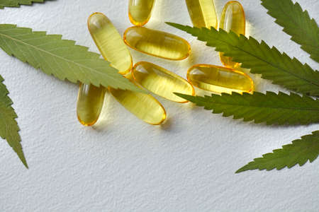 Medical cannabis products, leaf, capsules and CBD oil on white background. Pharmaceutical gelatin softgels with biological plant herbal. Organic dietary supplements conceptの写真素材