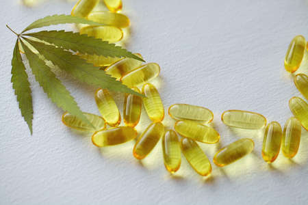 Medical cannabis products, leaf, capsules and CBD oil on white background. Pharmaceutical gelatin softgels with biological plant herbal. Organic dietary supplements conceptの写真素材