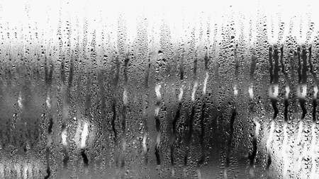 Background of condensation of water droplets on glass, humidity and fog behind glass, bad weather, rainの写真素材