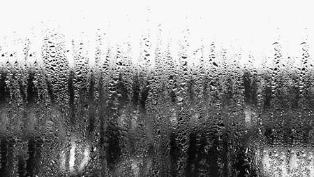 Background of natural condensation of water on transparent glass with high air humidity, large drops drippingの写真素材