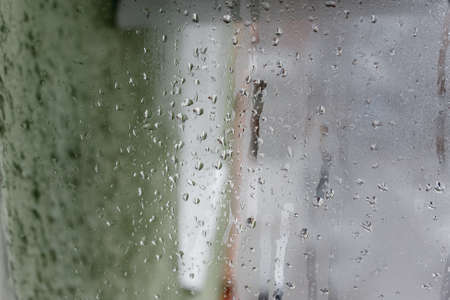 Condensation on the clear glass window, Water drops, Rain. Window glass with high air humidity. Background of natural water condensationの写真素材