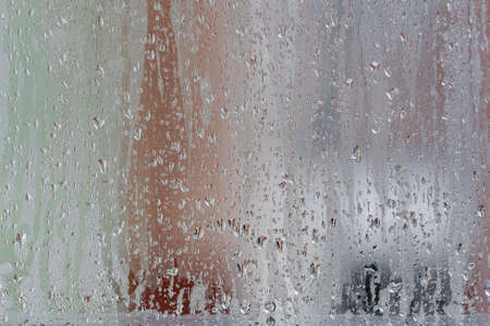 Condensation on the clear glass window, Water drops, Rain. Window glass with high air humidity. Background of natural water condensationの写真素材