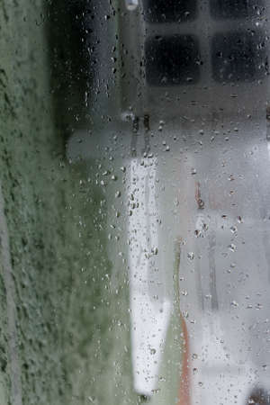 Background of natural water condensation, window glass with high air humidity, large drops drip. Collecting and streaming downの写真素材