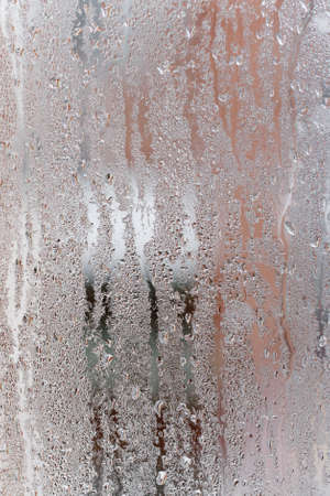 Condensation on the clear glass window, Water drops, Rain. Window glass with high air humidity. Background of natural water condensationの写真素材
