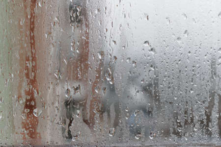Background of natural water condensation, window glass with high air humidity, large drops drip. Collecting and streaming downの写真素材