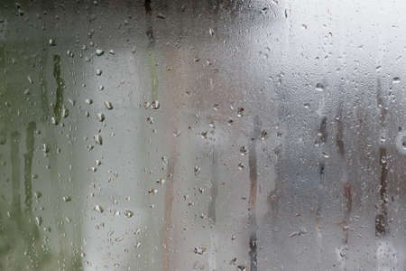 Background of natural water condensation, window glass with high air humidity, large drops drip. Collecting and streaming downの写真素材