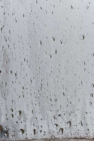 Condensation on the clear glass window, Water drops, Rain. Window glass with high air humidity. Background of natural water condensationの写真素材