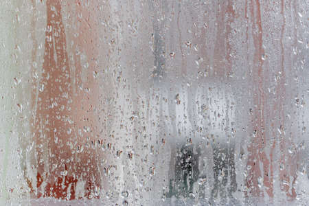 Background of natural water condensation, window glass with high air humidity, large drops drip. Collecting and streaming downの写真素材