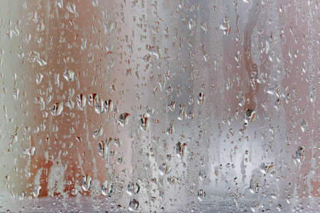 Condensation on the clear glass window, Water drops, Rain. Window glass with high air humidity. Background of natural water condensationの写真素材