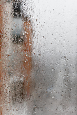 Background of natural water condensation, window glass with high air humidity, large drops drip. Collecting and streaming downの写真素材