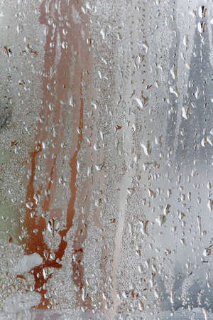 Condensation on the clear glass window, Water drops, Rain. Window glass with high air humidity. Background of natural water condensationの写真素材
