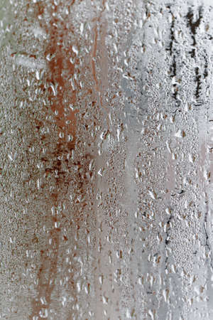 Condensation on the clear glass window, Water drops, Rain. Window glass with high air humidity. Background of natural water condensationの写真素材