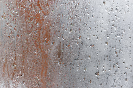 Background of natural water condensation, window glass with high air humidity, large drops drip. Collecting and streaming downの写真素材
