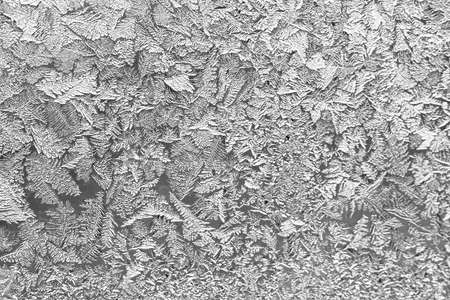 Frost on the window, Natural texture on glass with frozen pattern. Copy space, natural background, macro. Beautiful winter backgroundの写真素材