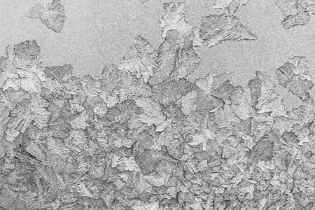 Frost on the window, Natural texture on glass with frozen pattern. Copy space, natural background, macro. Beautiful winter backgroundの写真素材