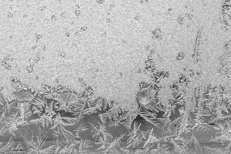 Frost on the window, Natural texture on glass with frozen pattern. Copy space, natural background, macro. Beautiful winter backgroundの写真素材